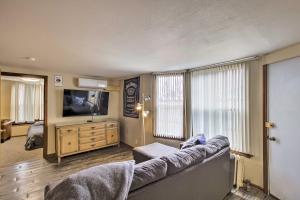 a living room with a couch and a flat screen tv at Downtown Sheboygan Apartment with Private Deck! in Sheboygan