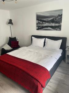 a bedroom with a large bed with a red blanket at Maple Lodge Apartments in Braşov