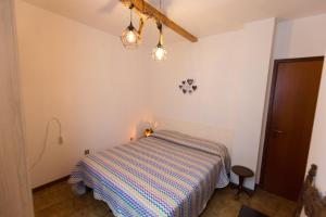 1 dormitorio con 1 cama con manta a rayas en Casa Federica, en Molina di Ledro