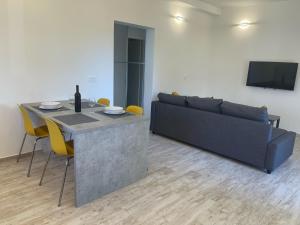 a living room with a couch and a table with yellow chairs at Apartments Demarin in Medulin