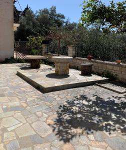two benches on a stone patio with a fence at Dionysus Apartments & Studios in Syvota