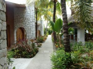 a pathway leading to a house with palm trees at Hotel Casa de Lirio Diamante in Acapulco