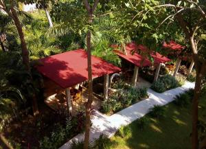 un complejo con techos rojos, árboles y plantas en Hotel Casa de Lirio Diamante en Acapulco