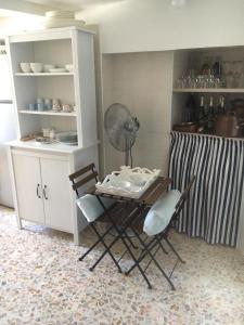 cocina con mesa, 2 sillas y ventilador en Borghetto Sul Mare, en Peschici