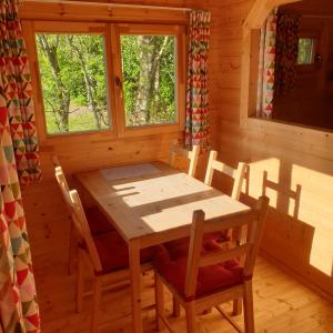comedor con mesa y sillas en una cabaña en Blokhut Plus Camping Alkenhaer, en Appelscha