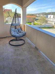 um alpendre com um baloiço numa varanda em Apartments Škara em Bibinje