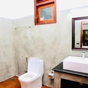 a bathroom with a white toilet and a sink at Manel Villa in Bentota +94 photos
