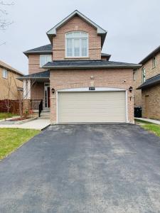 una casa con una puerta de garaje en una entrada en Clean, Beautiful & Modern 2 bedroom apartment, en Mississauga