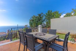 a table and chairs on a balcony with the ocean at Balancal Apartments and Villas Palheiro Village by Holiday Rental Madeira in Funchal +205 photos
