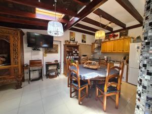 a kitchen with a table and chairs and a television at Almendro in Arico Viejo