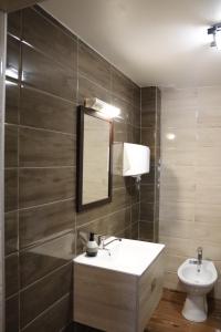 La salle de bains est pourvue d'un lavabo, d'un miroir et de toilettes. dans l'établissement Pensiunea Mara, à Mintiu
