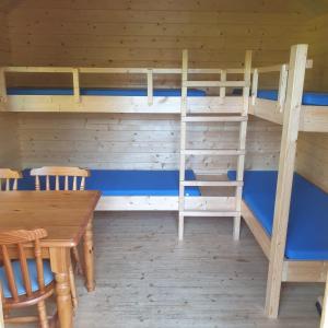 アッペルスカにあるBlokhut Camping Alkenhaerの二段ベッド、テーブル、椅子が備わる客室です。