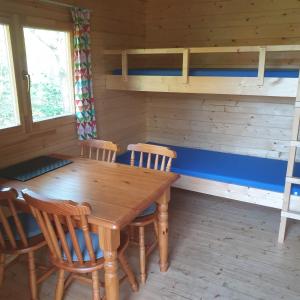 una sala da pranzo con tavolo e sedie in legno di Blokhut Camping Alkenhaer a Appelscha