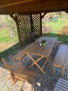 una mesa de picnic de madera y sillas bajo un cenador en Wakacyjny dom w Suchym Borze en Suchy Bór
