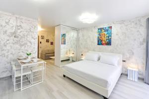 1 dormitorio con cama blanca, mesa y espejo en Color Studios in Nord10 - Pool & playground en Mamaia