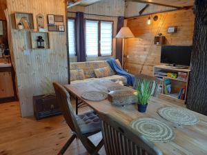 a living room with a wooden table and a couch at Cabane suspendue dans les arbres in Villebon-sur-Yvette