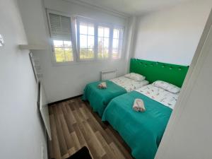 サンタンデールにあるApartamento tranquiloの小さな部屋のベッド2台 緑のシーツ付