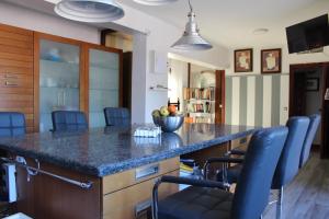 una cocina con una gran isla con sillas azules en Gran Villa familiar playa, en Marbella