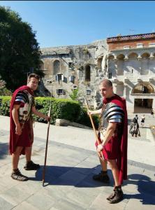 two men dressed in medieval clothing standing in front of a building at Palace Inn Rooms in Split