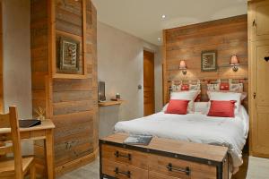 ein Schlafzimmer mit einem Bett und einer Holzwand in der Unterkunft Café-Hôtel Le Morillon, Domaine du Grand Massif-Samoëns in Morillon