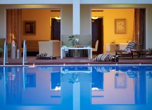 a house with a swimming pool and a living room at Sunshine Corfu Hotel And Spa in Nisaki