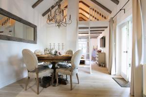 a dining room with a table and chairs and a chandelier at Vila Vilma Vineyard Cottage in Lendava