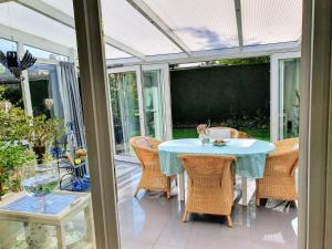 a conservatory with a table and chairs on a patio at Wunderschönes Ferienhaus in Strandnähe in Retranchement