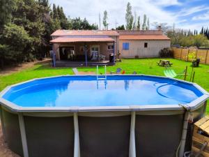uma grande piscina num quintal com uma casa em Maison piscine jeux à la campagne em Camélas