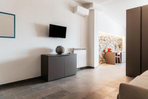 a living room with a couch and a tv on a wall at LA RIPA in Riomaggiore
