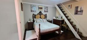 a bedroom with a bed with a wooden headboard and a staircase at CASA RIBEIRINHO No Coração da Natureza in Pedregal