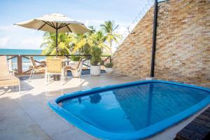 uma grande piscina azul num pátio com um guarda-sol em La Belle Beach Hotel em Natal