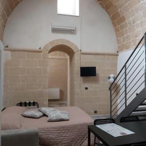 マテーラにあるDimora Margheritaのレンガの壁にベッド1台が備わるベッドルーム1室