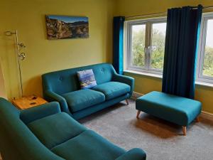 a living room with a couch and a chair at Bryn Melyn Apartments in Barmouth