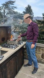 a man is cooking on a grill on a counter at Medieval Tower Lungarno your wedding in Tuscany in Pratovecchio