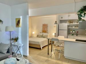 a kitchen and a living room with a bed in a room at Sea Breeze - Light in Bouzéïka