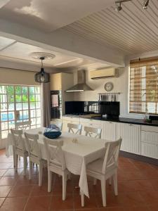 uma cozinha e sala de jantar com mesa e cadeiras em Shanti Villa em Flic-en-Flac