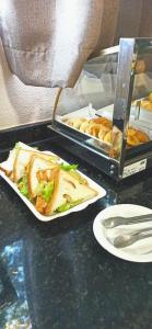 un tavolo con un panino e un piatto di cibo di HOTEL SAYMON a Cafelândia