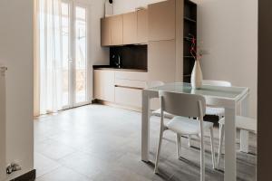 a kitchen with a white table and white chairs at LA RIPA in Riomaggiore