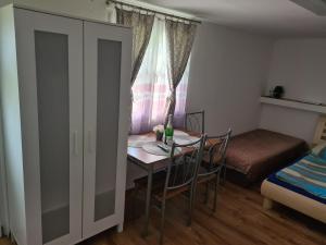 um quarto com uma mesa e um quarto com uma cama em Melanie apartman em Veľký Meder