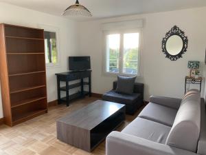 een woonkamer met een bank en een salontafel bij Appartement 2 pièces entre mer et campagne in Créhen