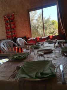 a dining room with a table and a large window at Gite Amoudou in Ouarzazate