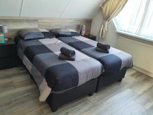 een slaapkamer met 2 bedden en handdoeken bij Stal Nieuwland in Vierpolders