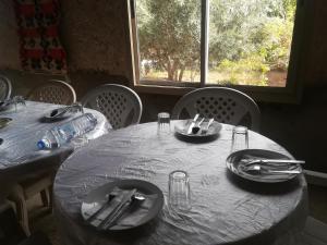a table with plates and silverware on top of it at Gite Amoudou in Ouarzazate