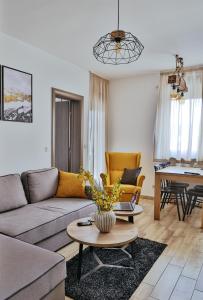 een woonkamer met een bank en een tafel bij Wood Stars Apartment Zlatibor in Zlatibor
