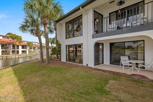 a house with a table and chairs on the balcony at Edgewater RESORT BEACH & GOLF Villa! Steps to the Beach! in Panama City Beach