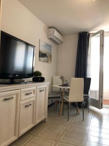 ein Wohnzimmer mit einem Flachbild-TV und einem Tisch in der Unterkunft Studio apartma Franca in Umag