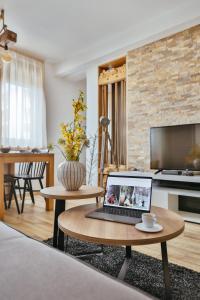 een woonkamer met een laptop op een salontafel bij Wood Stars Apartment Zlatibor in Zlatibor