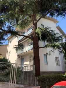 a large white building with a tree in front of it at Ghisello Luxury Guesthouse in Bologna