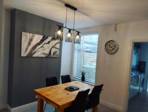 a dining room table with chairs and a clock on the wall at The Stone House II in Nottingham