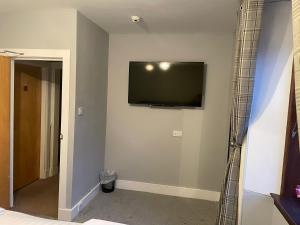 a room with a flat screen tv on a wall at Commercial Hotel (Insch) in Insch +14 photos